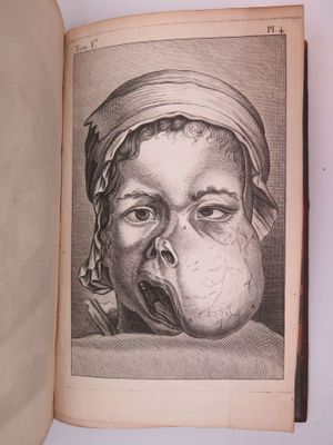 un vieux livre d'où sort un dessin représentant un bébé, par la bouche