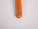 a small orange object on a white surface