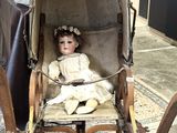une poupée assise dans une poussette, dans une pièce