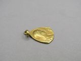 a close up of a gold pendant with a face on it