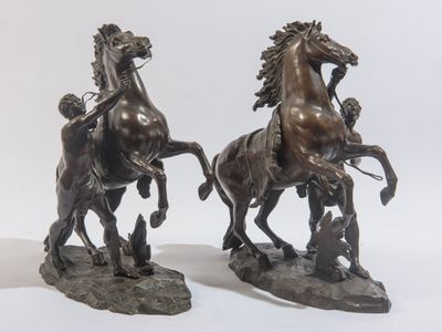 une paire de sculptures en bronze représentant des chevaux avec des cavaliers sur le dos