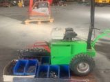 un chariot élévateur vert transportant une caisse dans un entrepôt