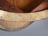 a close up of a hat on a wooden stand
