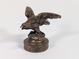 une statue représentant un aigle sur un socle, sur fond blanc
