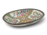 a close up of a bowl on a white surface with people in the background