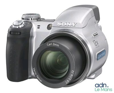 a silver digital camera that is sitting on a white surface