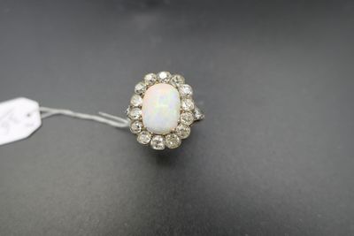 une bague sertie d'un oplite et d'un groupe de diamants