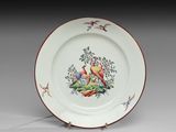 une assiette blanche ornée d'un motif représentant un oiseau et des fleurs
