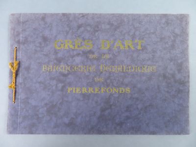 an old book with gold lettering on it sitting on a table
