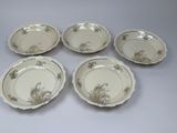 four plates with a design of flowers and leaves on them