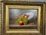 a picture of a painting of grapes and apples in a gold frame