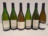 six bottles of wine are lined up in a row on a table