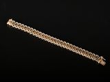 gros plan d'un bracelet en chaîne en or sur une surface noire