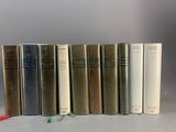 plusieurs livres sont alignés sur une surface blanche