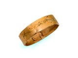 un gros plan d'une bague portant une inscription, posée sur une surface blanche
