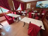 des tables et des chaises dans un restaurant, recouvertes de rideaux rouges