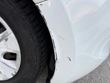 a white car that has a flat tire on the side of the road