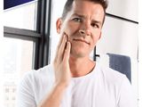 a man holding his hand to his face and looking at the camera