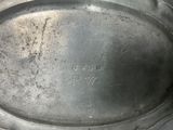 a silver plate with a silver handle on a table