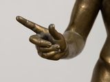 a bronze statue of a woman holding a cell phone