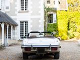 a white car parked in front of a large house