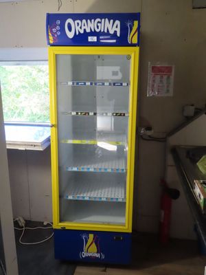 yellow and blue vending machine sitting in a kitchen next to a window