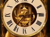 a gold clock with roman numerals on it