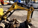 a yellow excavator that is sitting on the side of the road