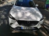 a white mazda car parked on the side of the road