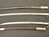 four different types of swords are displayed on a table