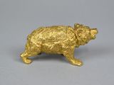 a gold bear figurine on a gray surface