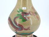 un vase orné d'un dragon peint, posé sur un socle
