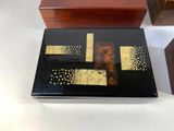 a black and gold box sitting on a table next to a wooden box
