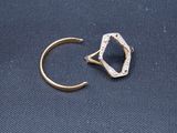gros plan d'une bague en or surmontée d'un diamant