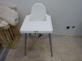a white high chair that is sitting on the floor