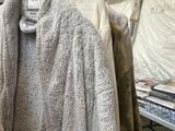 many coats hanging on a rack in a room