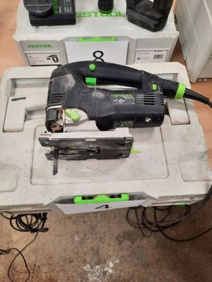 a corded jig saw and two other tools on the table