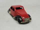 a red toy car that is sitting on a white surface