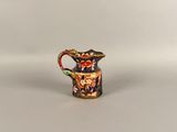a small vase with a bird on it sitting on top of a table