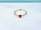 a gold ring with a brown stone on top