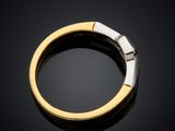 a close up of a gold and silver ring on a black surface