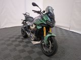 une moto verte garée sur un sol à carreaux noirs et blancs