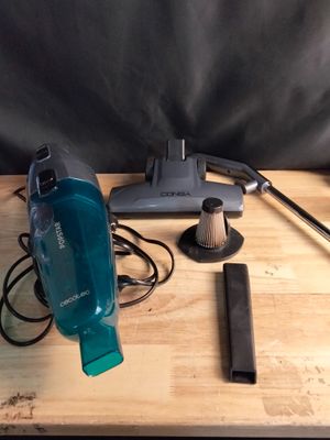 Quelqu'un utilise un aspirateur pour nettoyer une table en bois.