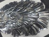 a silver brooch with a large feather on it