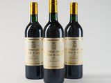 three bottles of wine sitting next to each other on a white surface