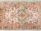 un tapis persan antique avec un motif floral sur fond blanc