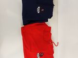 trois paires de pantalons rouges et bleus posés sur une surface blanche