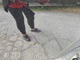 a reflection of a person holding an umbrella in the rain