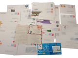 de nombreuses lettres et enveloppes disposées sur une surface blanche