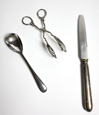 deux cuillères et un couteau sur une table blanche
